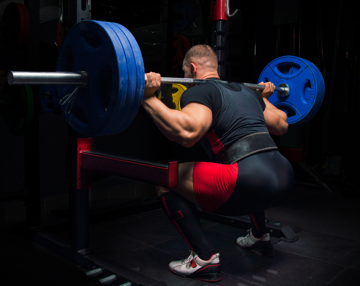 Professional athlete makes squats with a bar